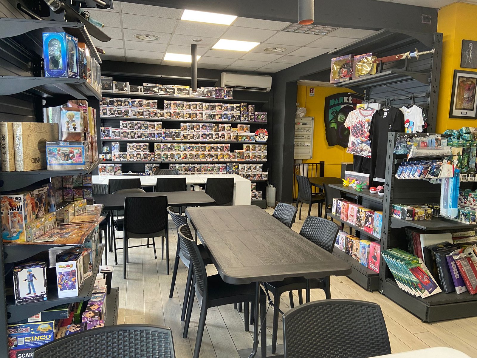 Interno del negozio Dark Zone a Roma: tavoli da gioco e scaffali, sede dei tornei Riftbound del sabato