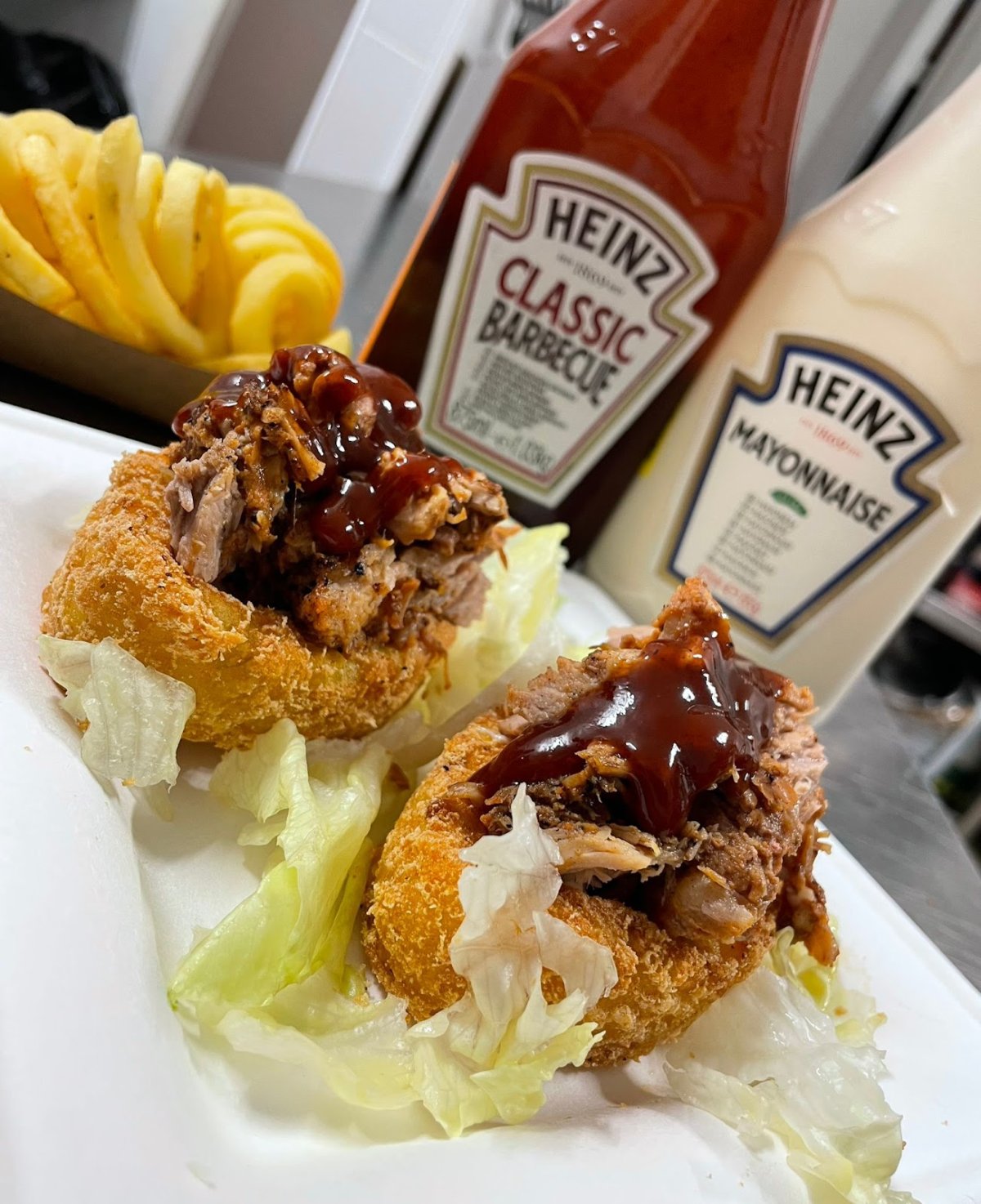 Onion ring con pulled pork e patatine della cucina del pub Dragon Legend a Roma