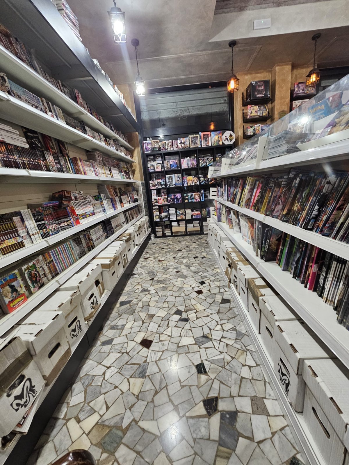 Scaffali di manga e fumetti nel corridoio della fumetteria Dragon Legend a Roma