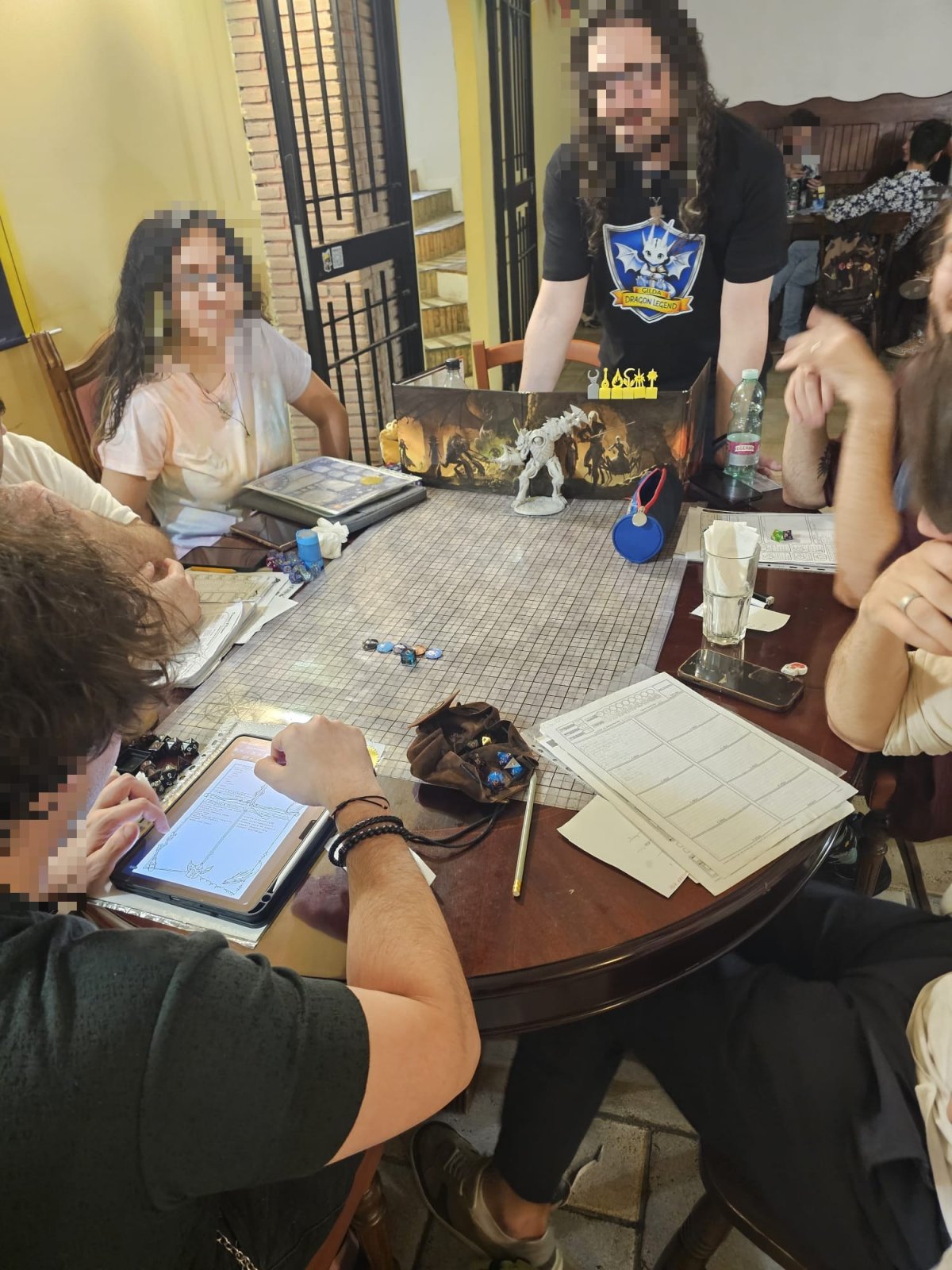 Tavolo di gioco di ruolo da Dragon Legend a Roma con schermo del master, miniature e schede