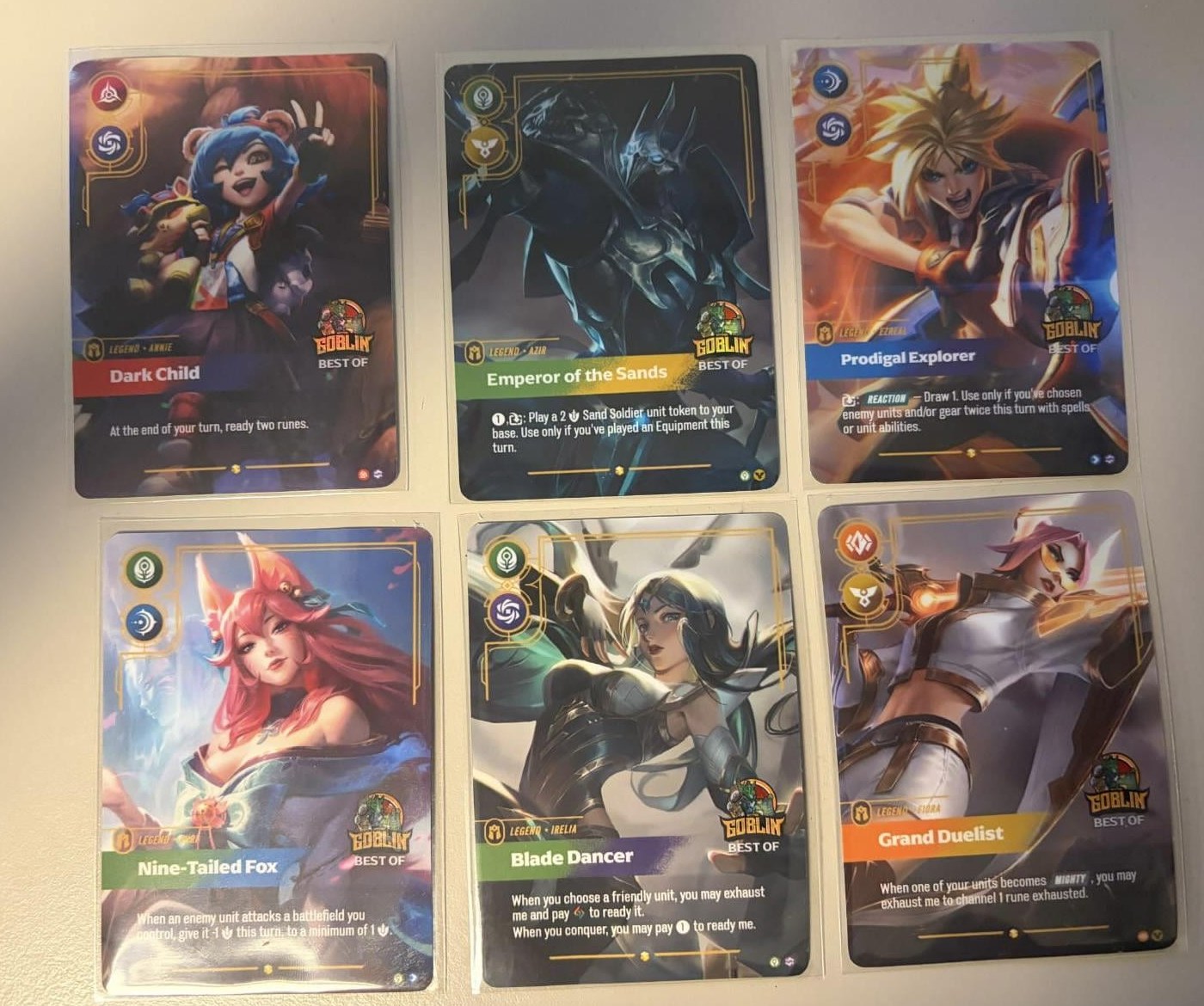 Sei carte Best Of stampate dal negozio Goblin: Annie, Azir, Ezreal, Ahri, Irelia e Fiora, tutte con il logo del negozio e la fascia Best Of
