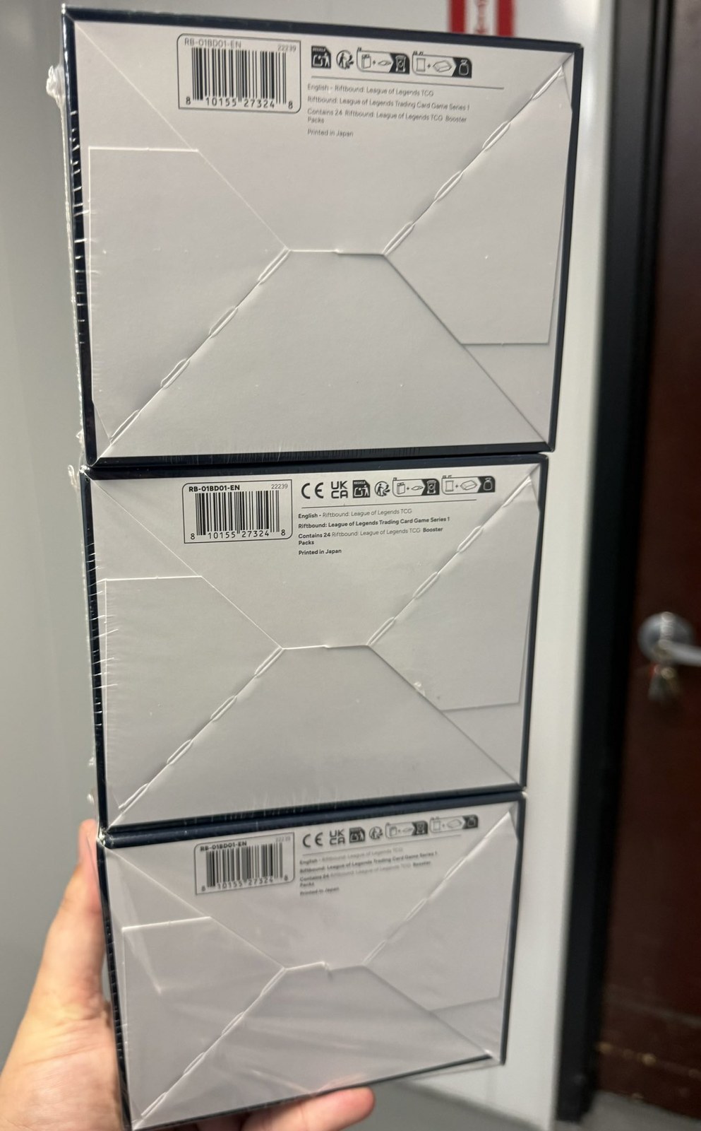 Fondo di tre box Origins impilati: in alto la ristampa senza CE e UKCA, sotto due prima wave