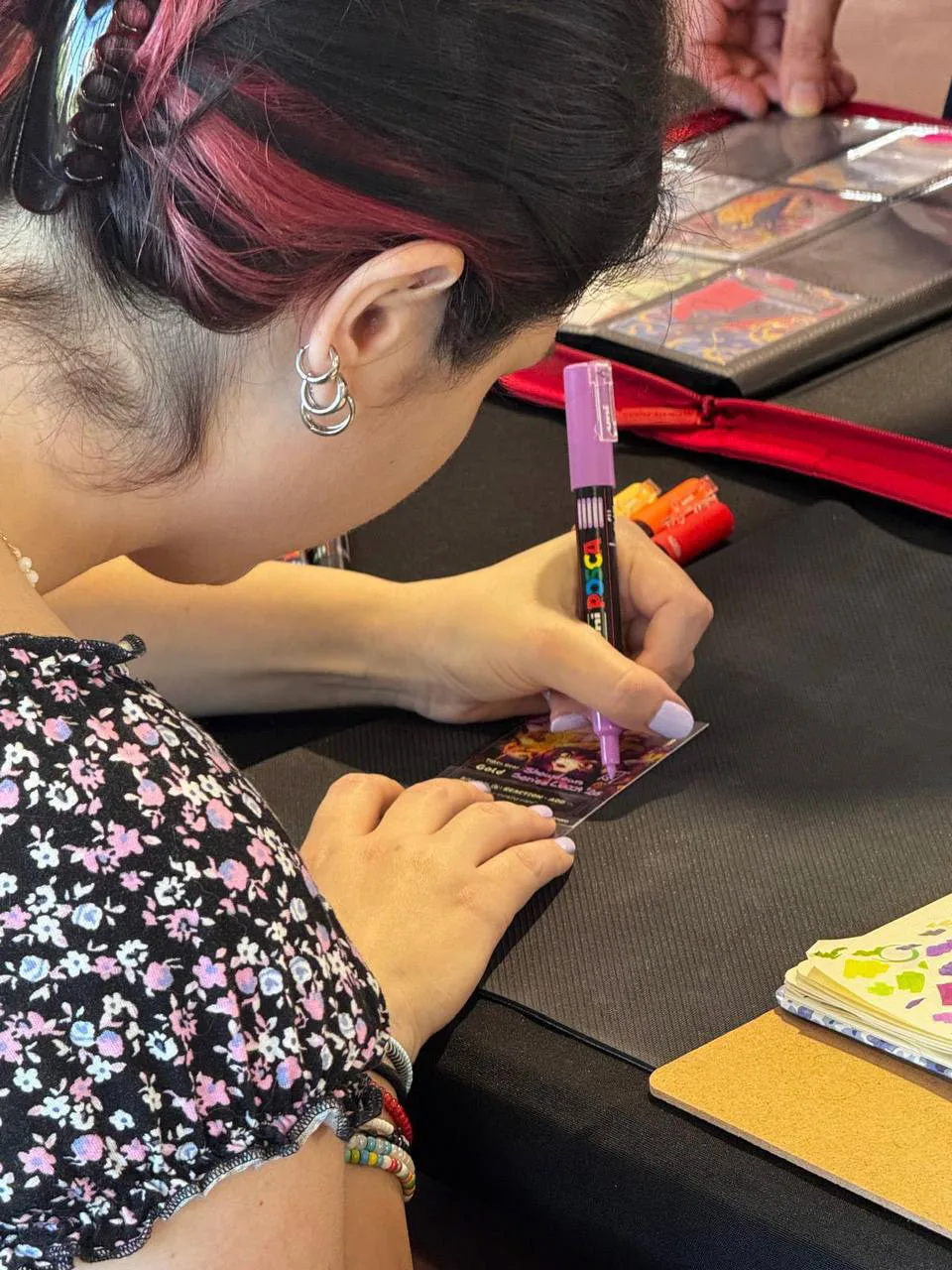 Valentina Stagnaro di profilo mentre dipinge una carta con un marker rosa